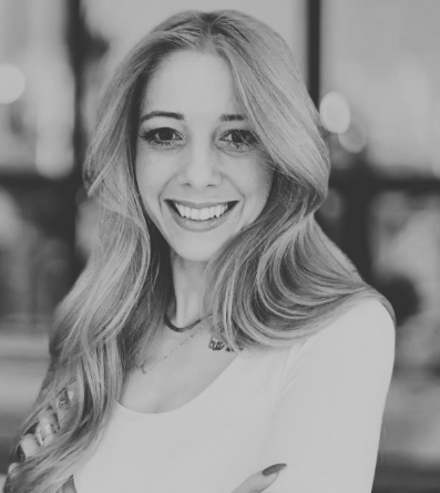 Woman with long hair smiling with arms crossed